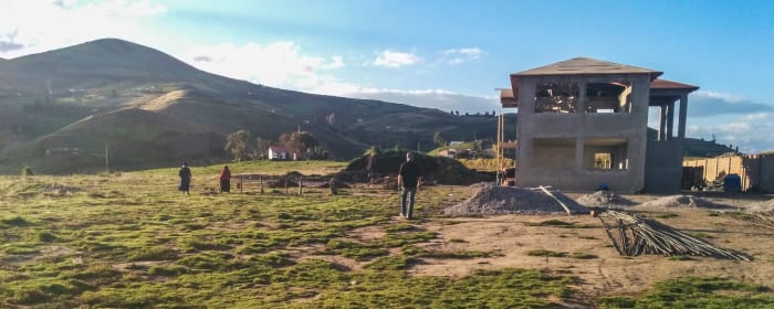 Grassy field with concrete building under construction