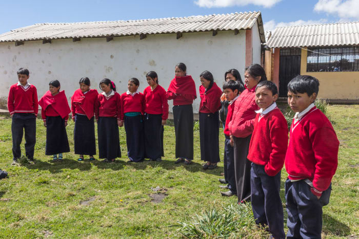 School kids standing outside wearing red school uniforms