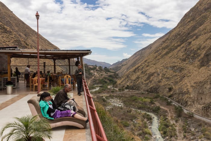 People lounging in chairs in café overlooking the valley below