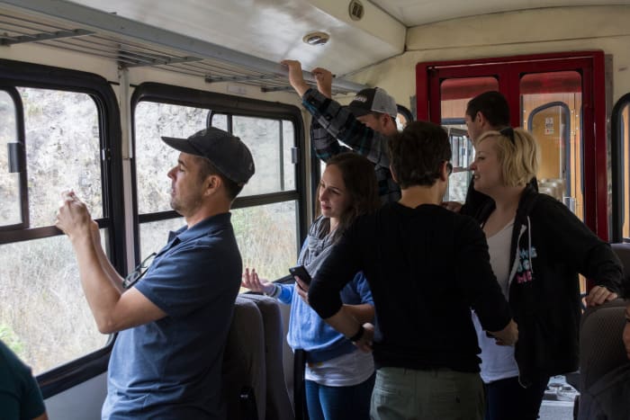 People inside a train car crowded around the windows taking photos
