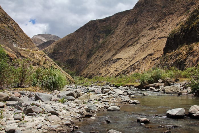 Mountains, valley, and river with rocks in the landscape