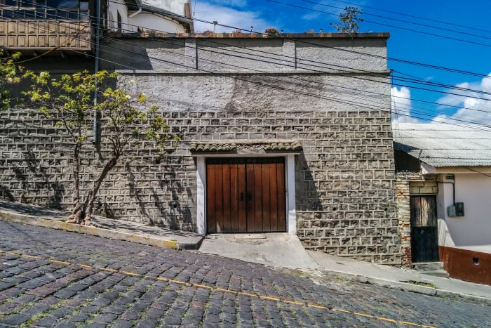 Steep cobblestone road with building and garage