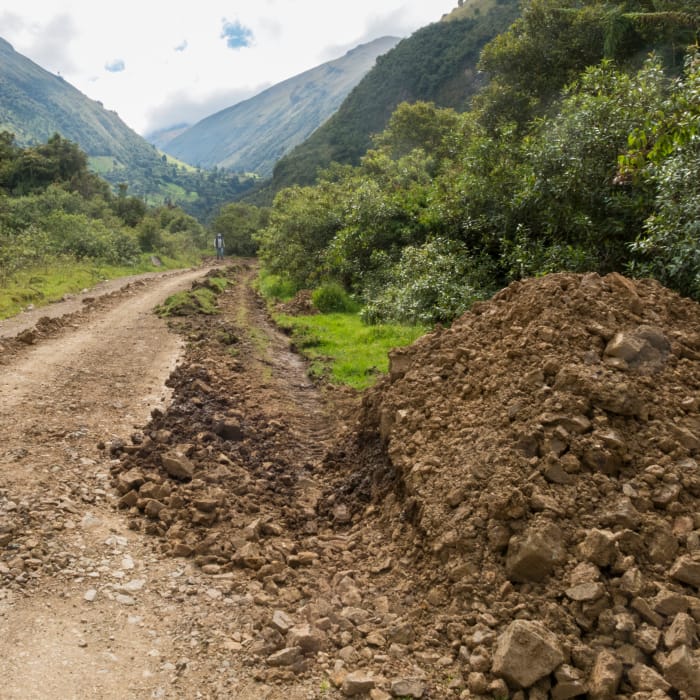 A partially washed-out dirt road going up the mountain towards the hacienda