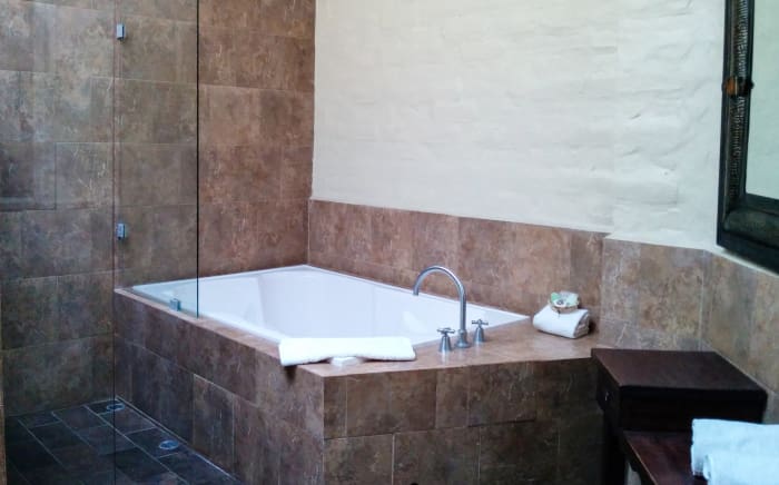 Tiled hotel bathroom interior with large soaker bathtub