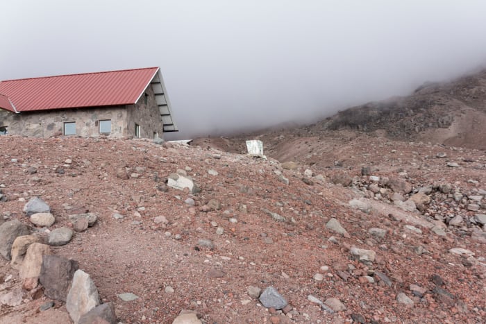 Refugio Whymper cabin on mountain hillside in the clouds