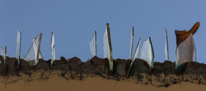 Broken glass embedded into the top of an exterior concrete block fence