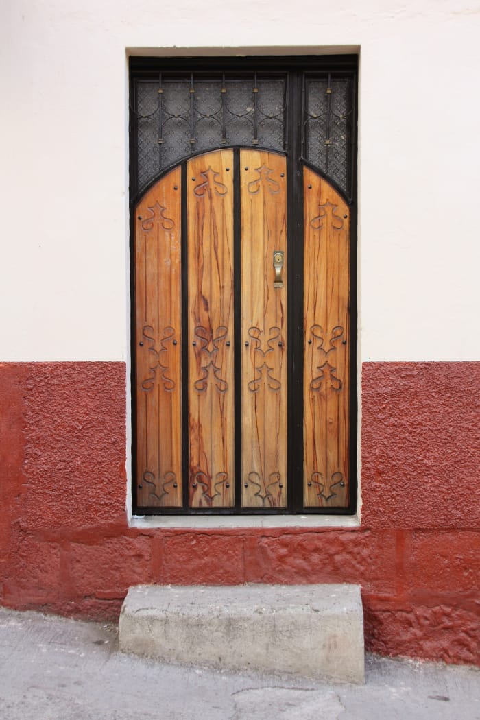 Wood door inset into stucco wall